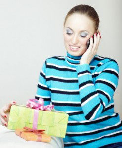 Woman on cell phone holding a gift